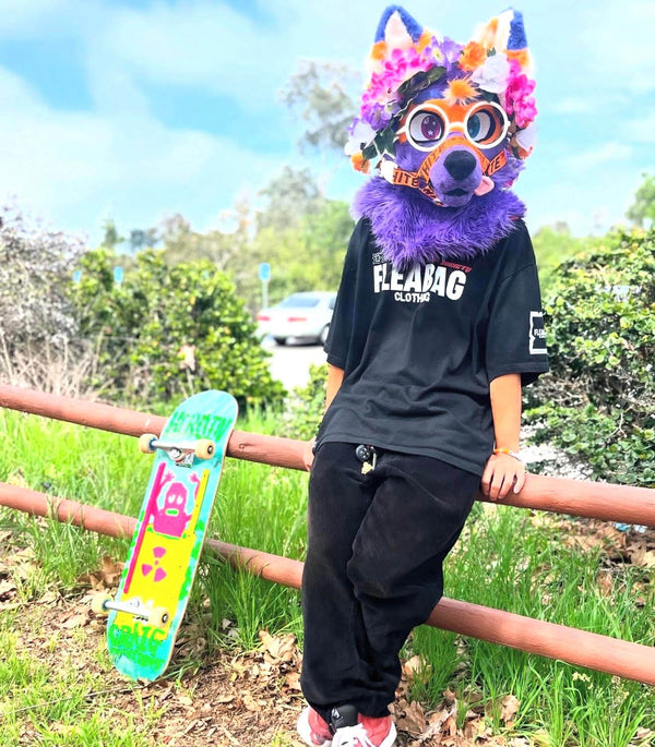 Model wearing Simply Animals Tee near skateboard.